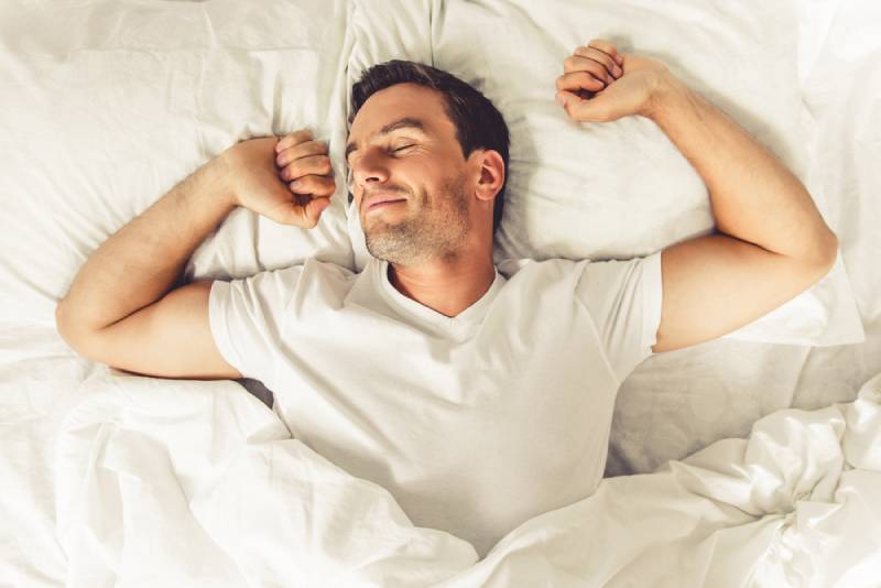 man selleping in clean sheets to prvent acne
